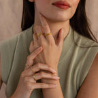 The model wears multiple golden rings in a stylish look, including a “1994” Bubble Numbers Ring on her middle finger.