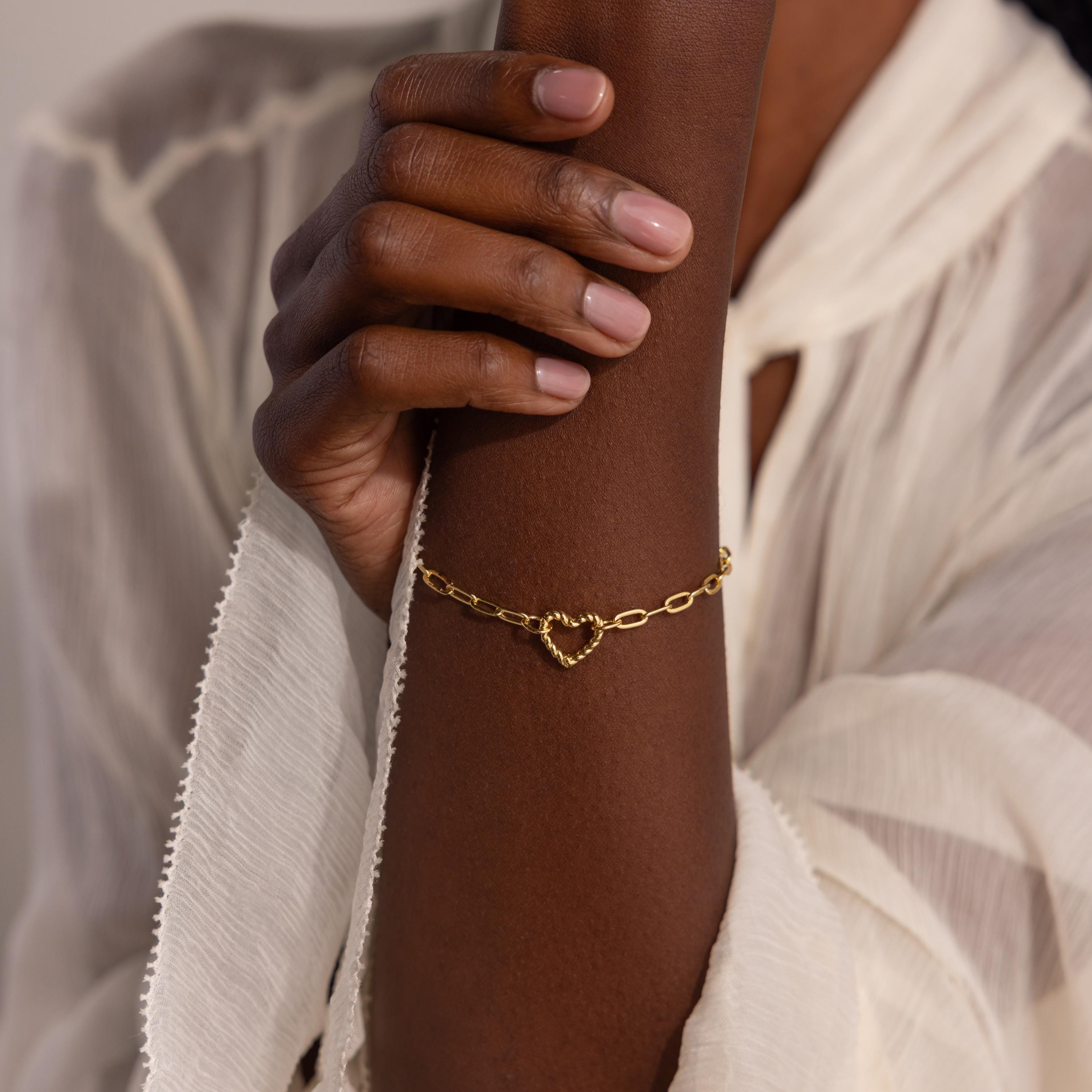 Gold Heart Carabiner Paperclip Bracelet styled on wrist with heart clasp detail centered.