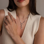 A silver version of the celestial hand and star pendant is worn on a silver paperclip chain necklace with a circular bail.