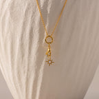 Gold North Star Hand Charm hangs off of a rolo clasp necklace