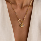 A gold paperclip-style chain necklace is shown worn with a Simple Heart Charm and a pavé marquise charm, styled together on a carabiner lock.