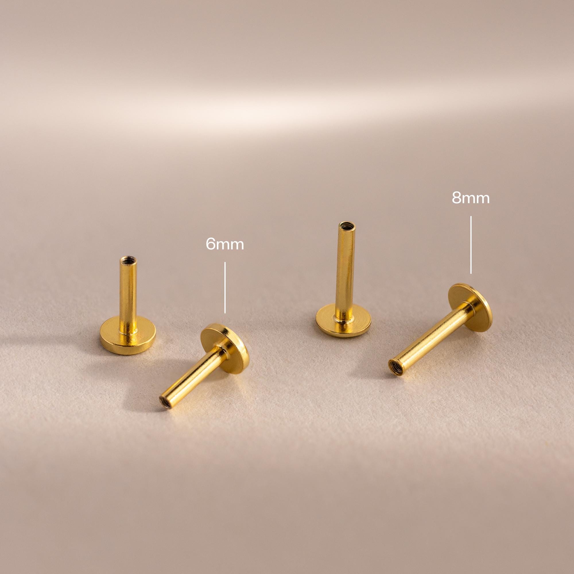 Four 18k gold Flat Back Posts shown from multiple angles on a softly lit matte surface.