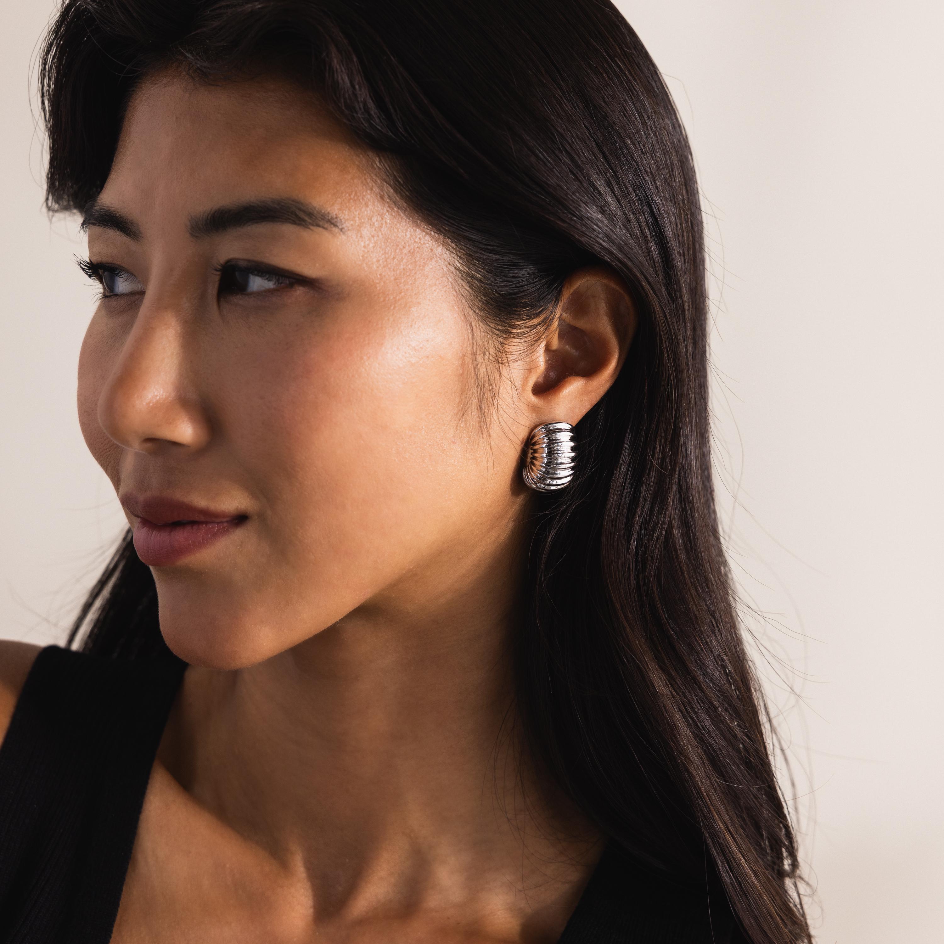 Model wearing silver ribbed earrings
