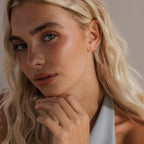 Model wearing a single opal cluster stud on her ear, with a soft, natural makeup look and styled blonde hair.