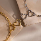 Close-up of both gold and white gold Heart Carabiner Paperclip Bracelets with interchangeable heart charms.