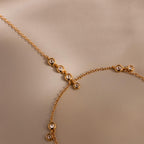 Macro shot of gold chain with bezel-set diamonds on a neutral background.