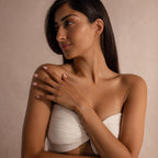 Close-up of a woman’s hand wearing a minimalist silver hand chain bracelet, with the chain extending from finger to wrist, styled with a neutral background.