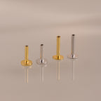 The Flatback Post Set features two gold and two silver posts arranged in a row on a reflective surface, highlighting their sleek design ideal for everyday ear jewelry.