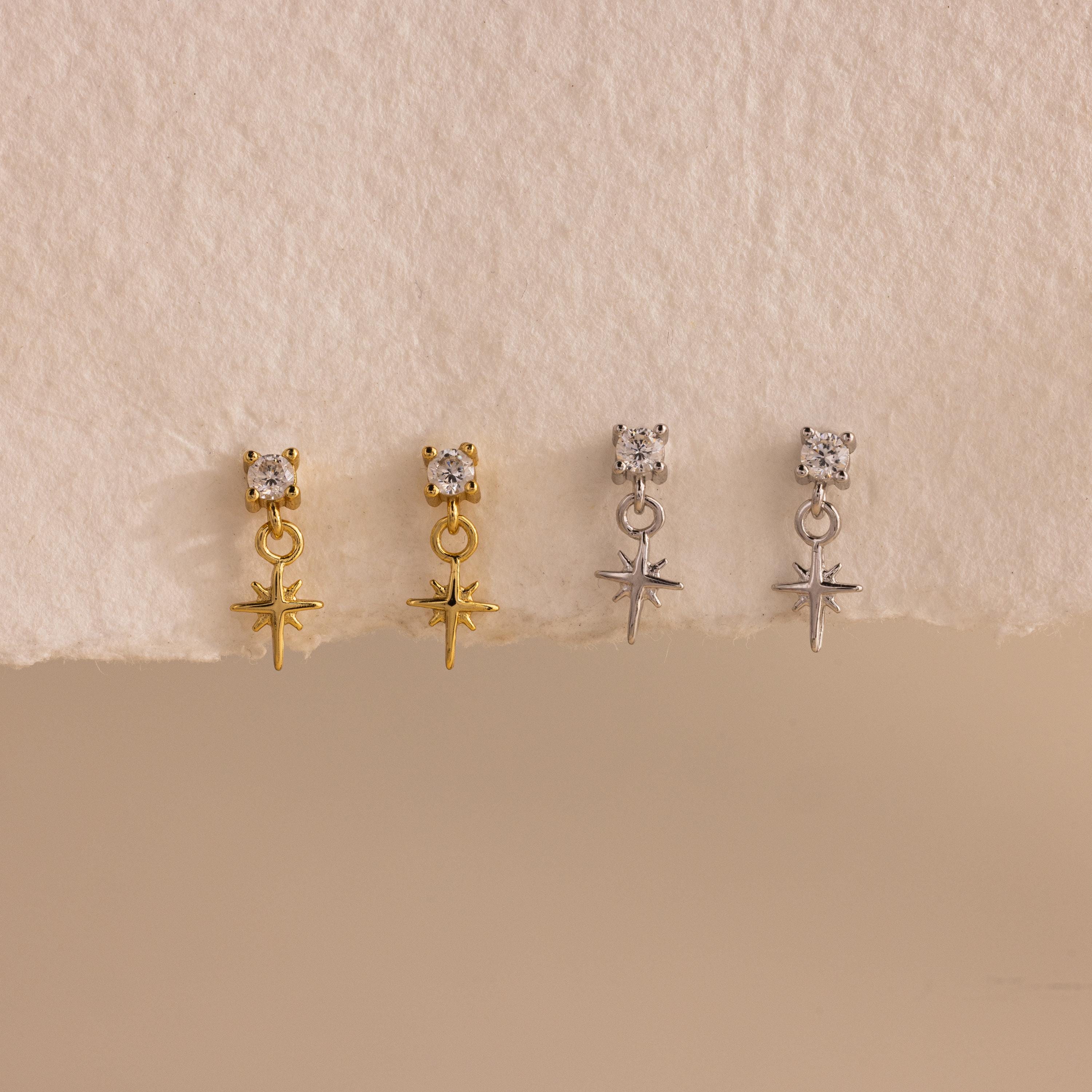A side-by-side product display of all finish options: two pairs of 18k gold earrings and two pairs in sterling silver, lined up evenly on a softly textured white surface.