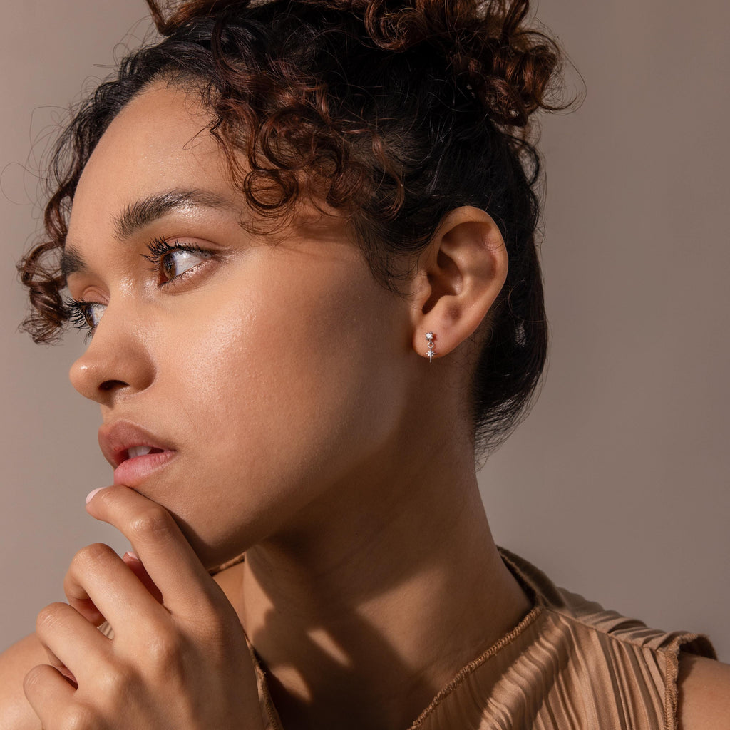 Model wears silver diamond star fatback earring and faces to the side