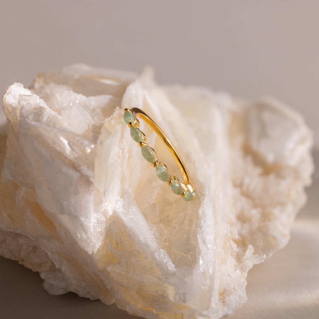 Marquise jade ring balanced on a large, translucent quartz crystal, capturing the ethereal beauty of the piece in natural light.