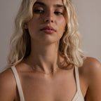 Portrait of a woman wearing the Dainty Bow Necklace in gold, styled simply to highlight the necklace’s refined and feminine charm.