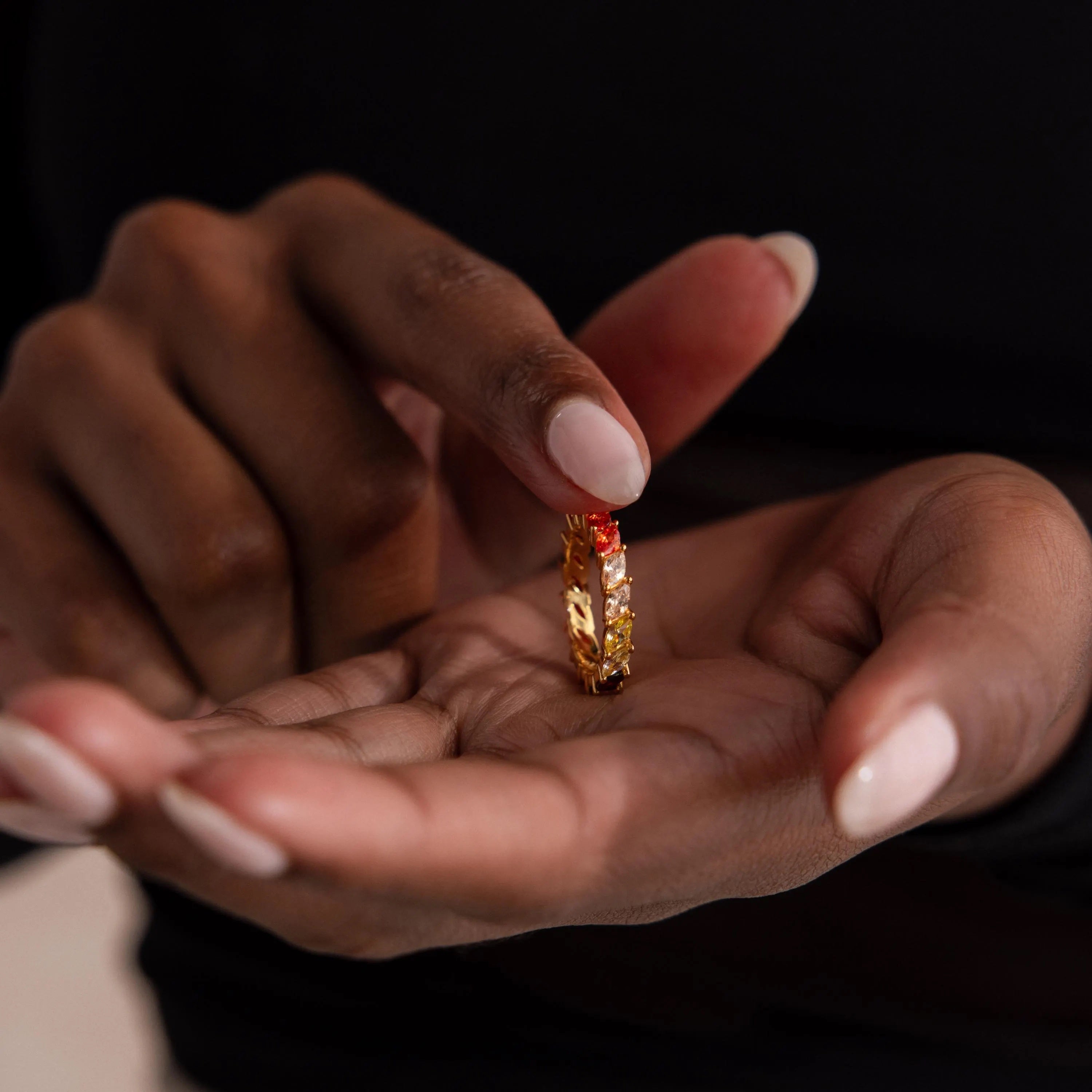 Model holding a Red Marquise Ombre Ring with gradient marquise-cut stones in gold setting.