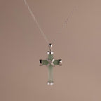 Silver chain necklace with a jade cross pendant, featuring polished silver end caps and an X-shaped detail at the center.