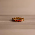 Red Marquise Ombre Ring with gradient marquise-cut stones in gold setting, placed against a soft neutral background.