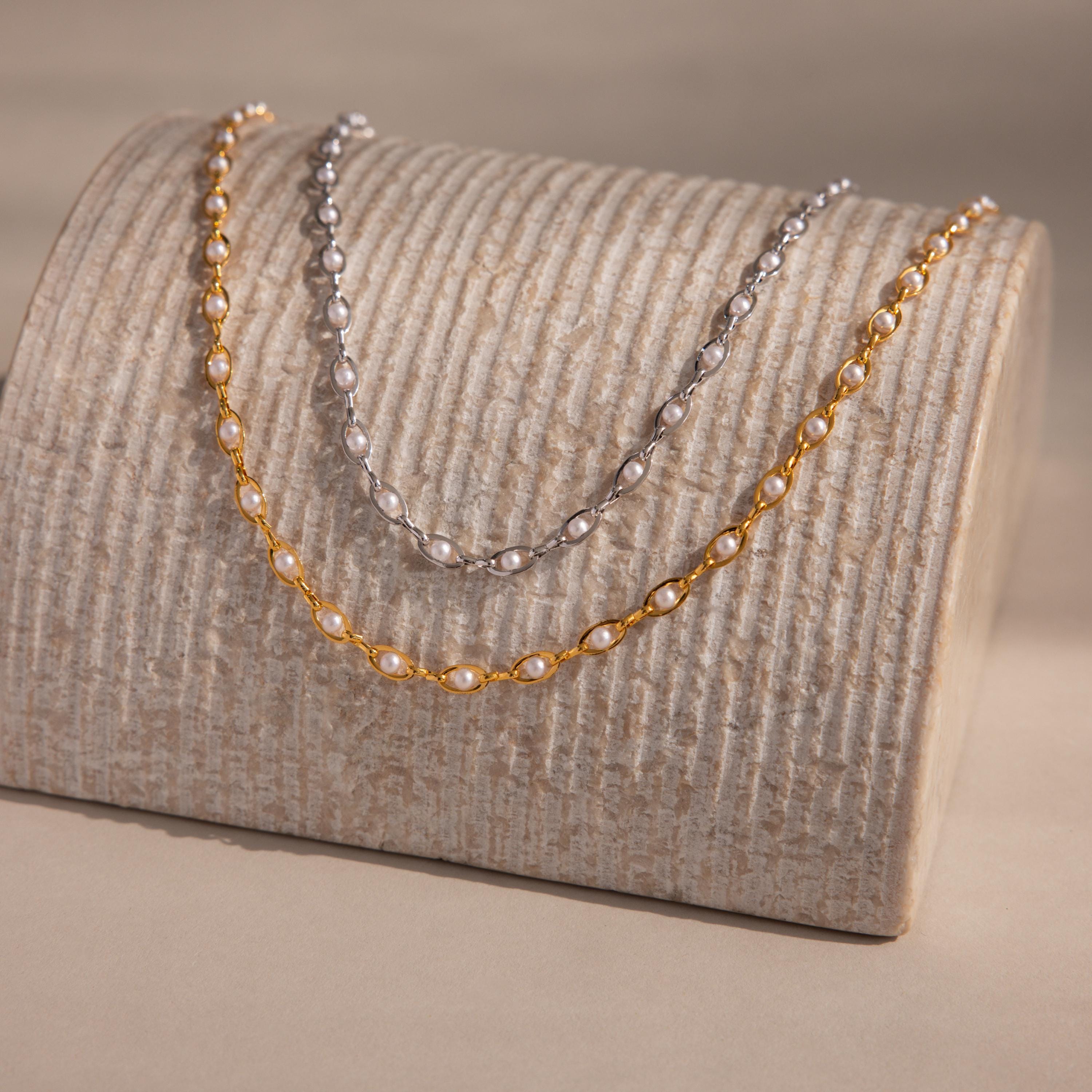 The Eternity Pearl Choker Necklace displayed on a textured beige stand, perfect for showcasing timeless beauty and ideal as elegant wedding jewelry.
