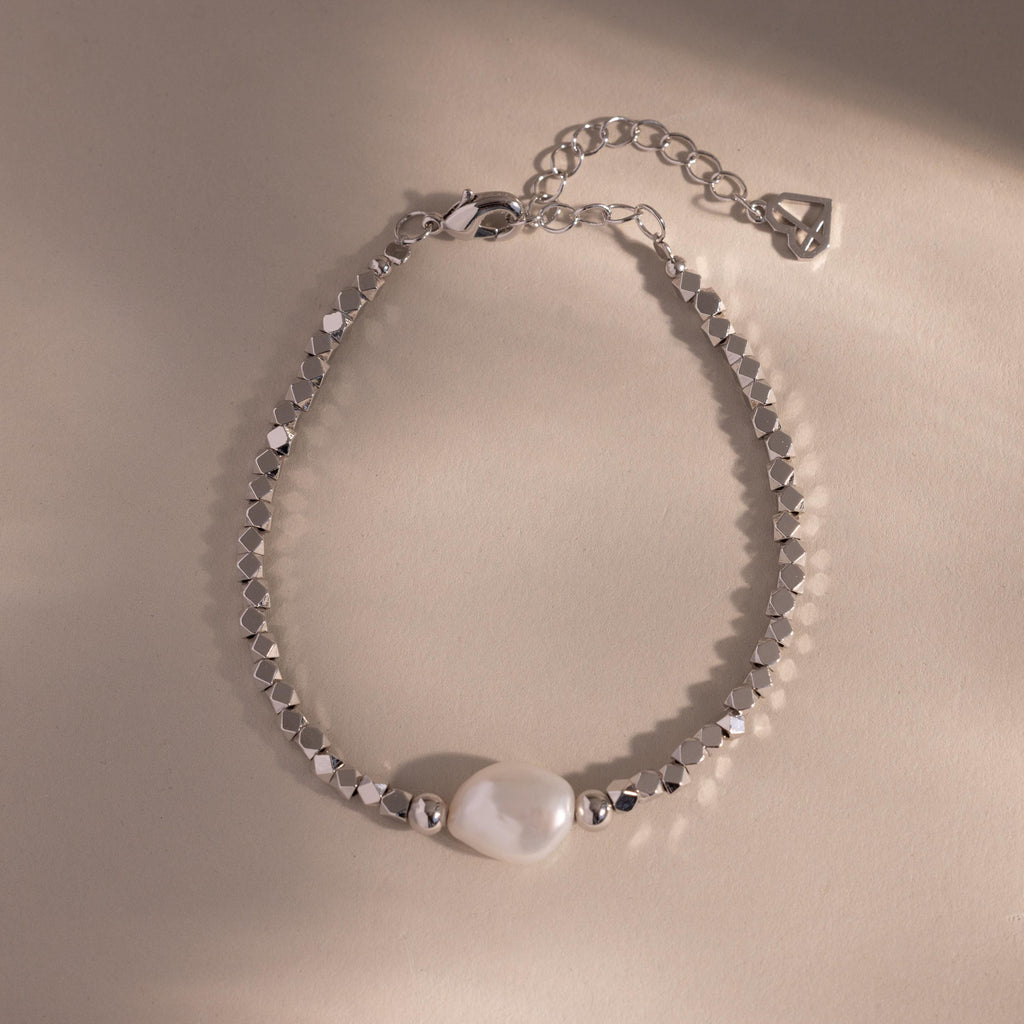 Beaded Pearl Bracelet in silver featuring faceted metallic beads with a single natural white pearl centerpiece, displayed on a neutral background for a sleek, modern look.