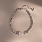 Beaded Pearl Bracelet in silver featuring faceted metallic beads with a single natural white pearl centerpiece, displayed on a neutral background for a sleek, modern look.