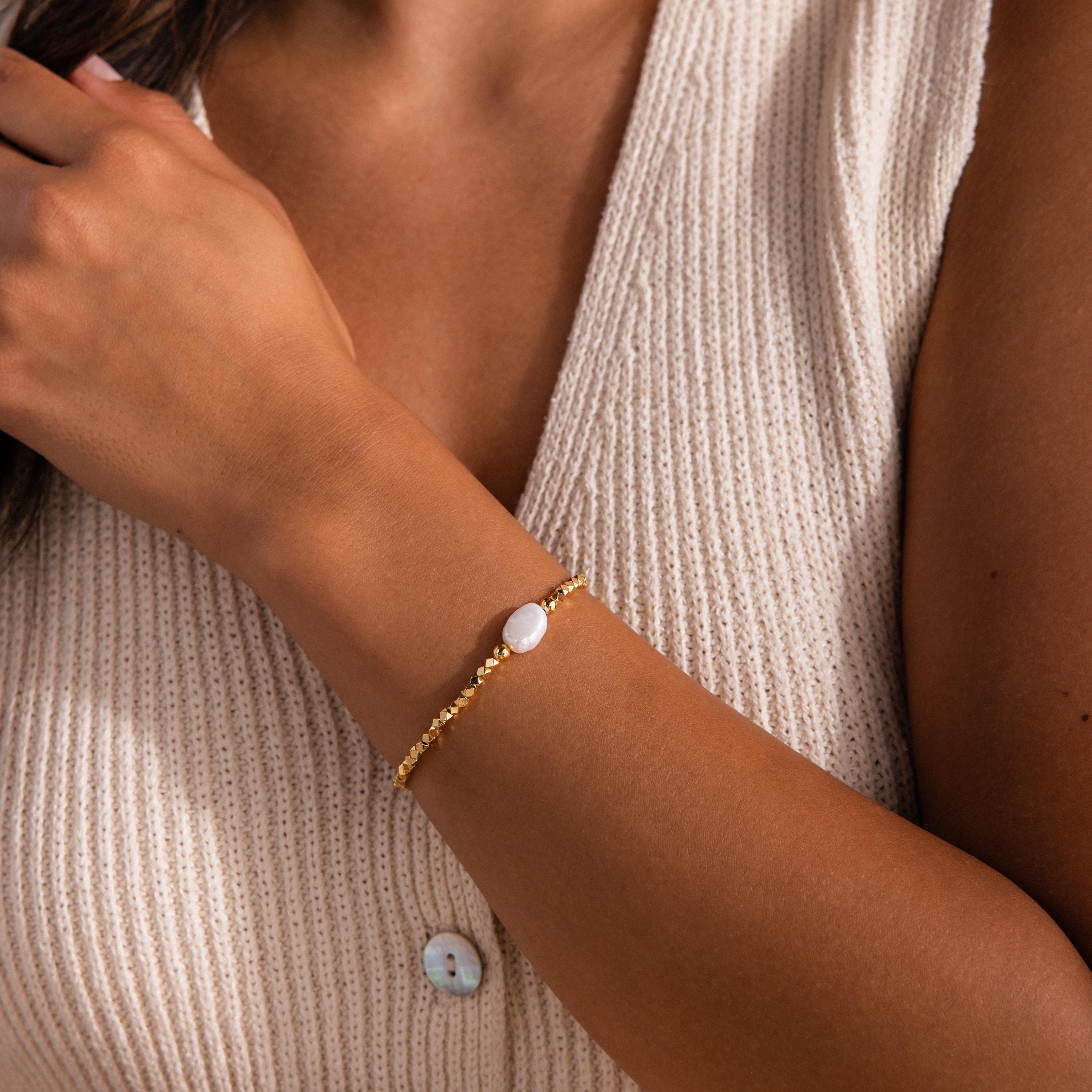 Beaded Pearl Bracelet featuring small faceted gold beads with a single natural white pearl centerpiece, styled on the wrist for a delicate and elegant look.