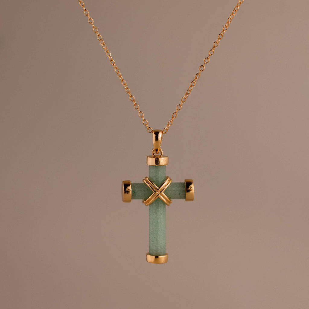 Gold chain necklace featuring a green jade cross pendant with polished gold end caps and a gold X-shaped accent at the center.
