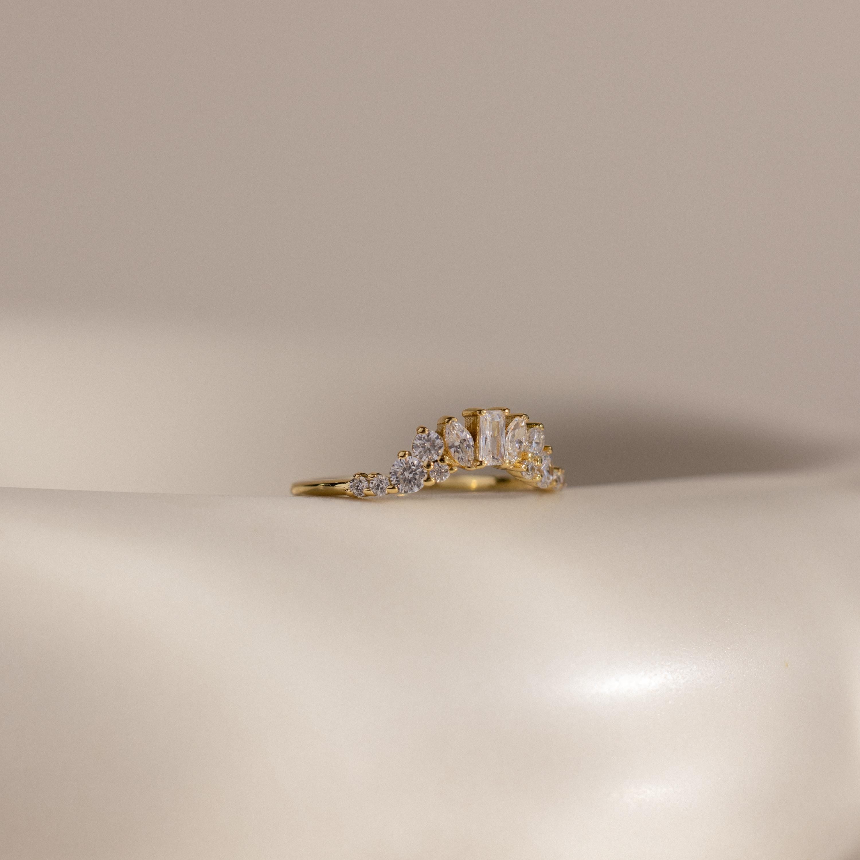 The Diamond Curve Cluster Ring is shown on a smooth, off-white surface with a neutral background.