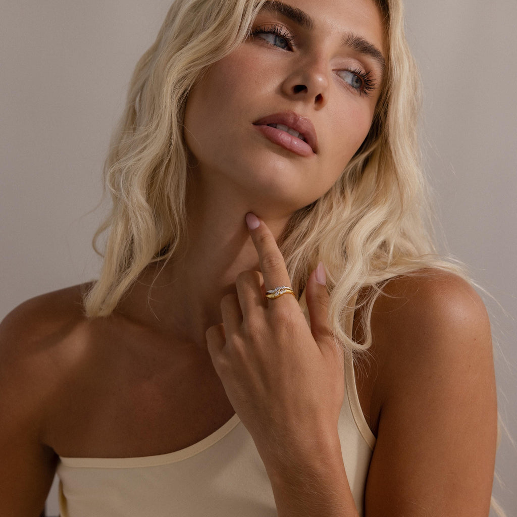 Model wearing stacked gold and silver curve rings with marquise cut stones, styled on her finger for a modern, elegant look.