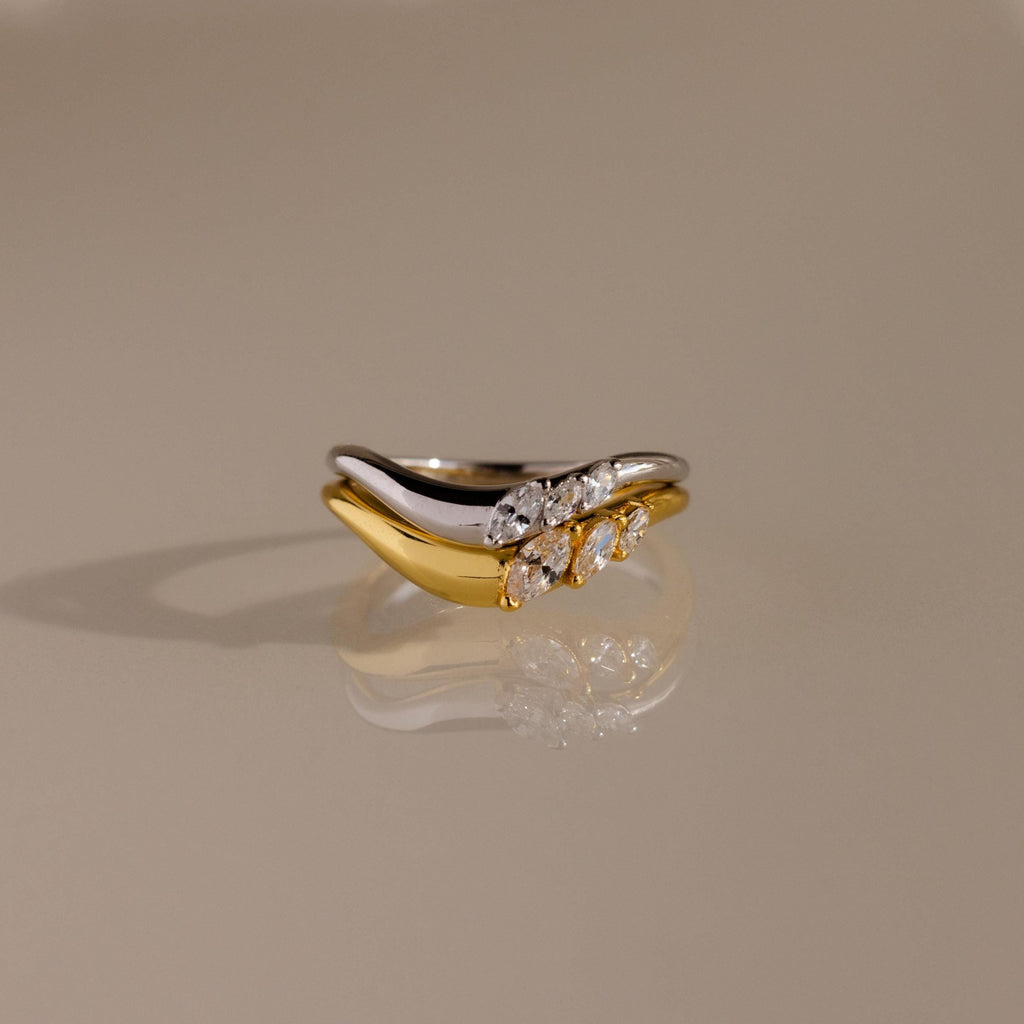 Stacked gold and silver curve rings with marquise cut stones, designed in a wavy silhouette for an elegant and modern look.