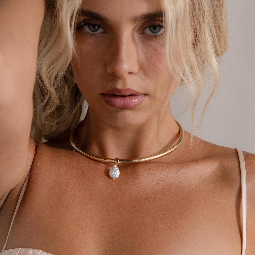 Blonde-haired woman wears the Pearl Cuff Choker Necklace in 18K Gold with a round pendant and a spaghetti strap top.