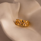 Set of 3 eternity curve rings in gold with quilted detailing and diamond accents, displayed on soft cream fabric for a refined and luxurious jewelry presentation.