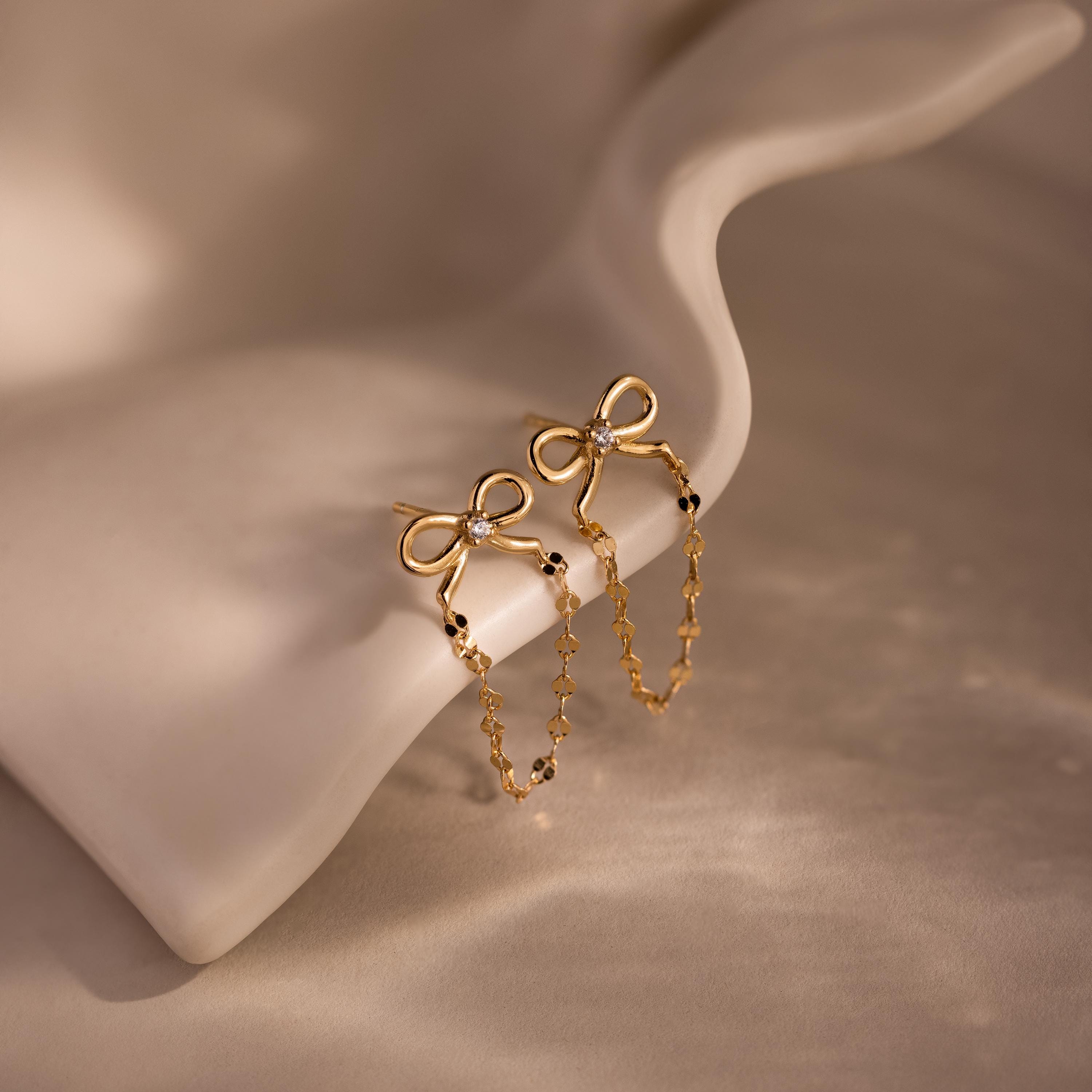 Bow Chain Studs featuring delicate chain details, showcased on a curved cream surface—ideal for those who love feminine and vintage-inspired jewelry styles.