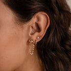 Close-up of a womans ear with three piercings, featuring the Bow Chain Studs in 18K Gold—a perfect choice for lovers of vintage-inspired jewelry.