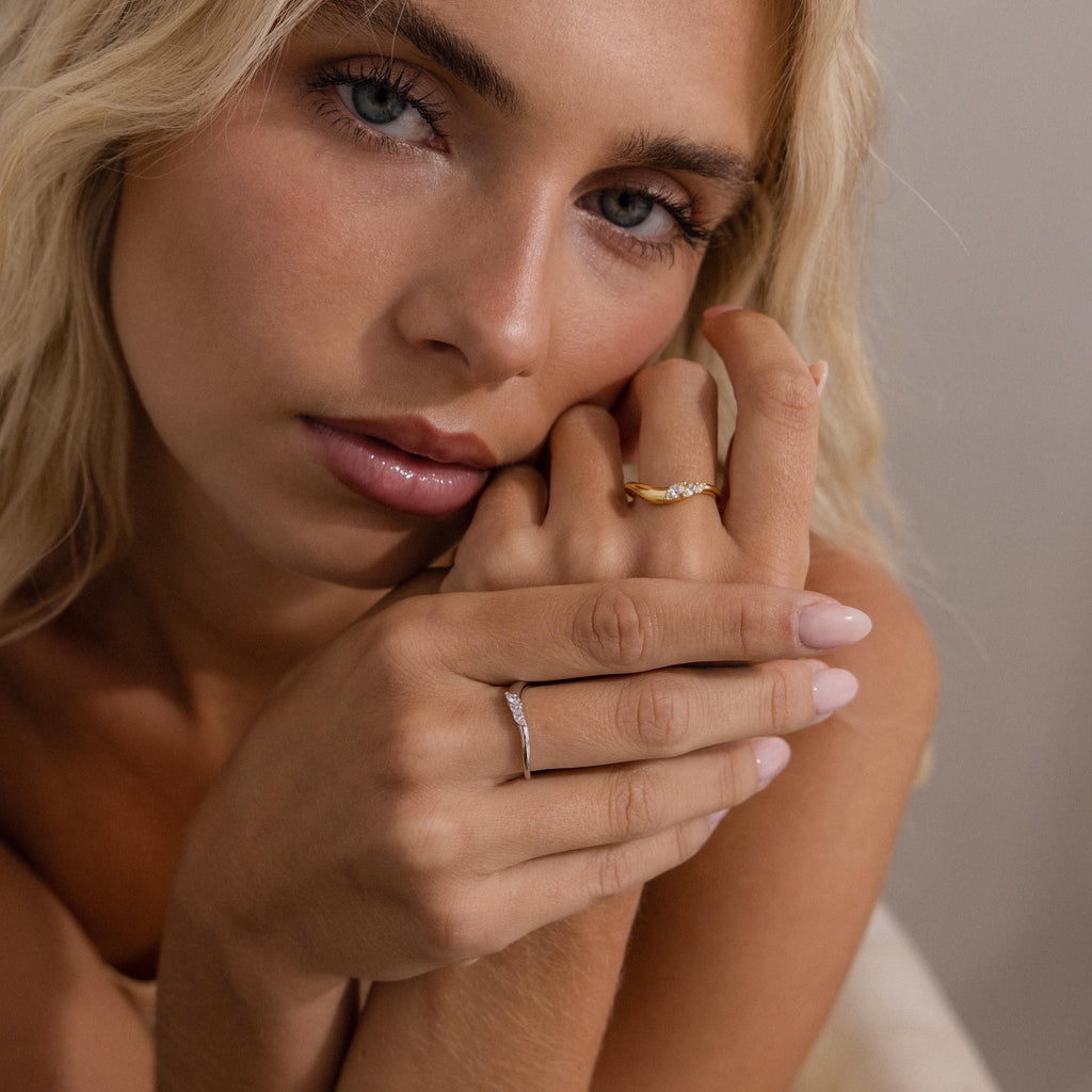 Model wearing gold and silver curve rings with marquise cut stones, styled together for a chic stacked ring look.