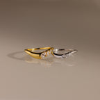 Gold and silver curve rings with marquise cut stones, designed in a sleek wavy silhouette for stacking or standalone wear.