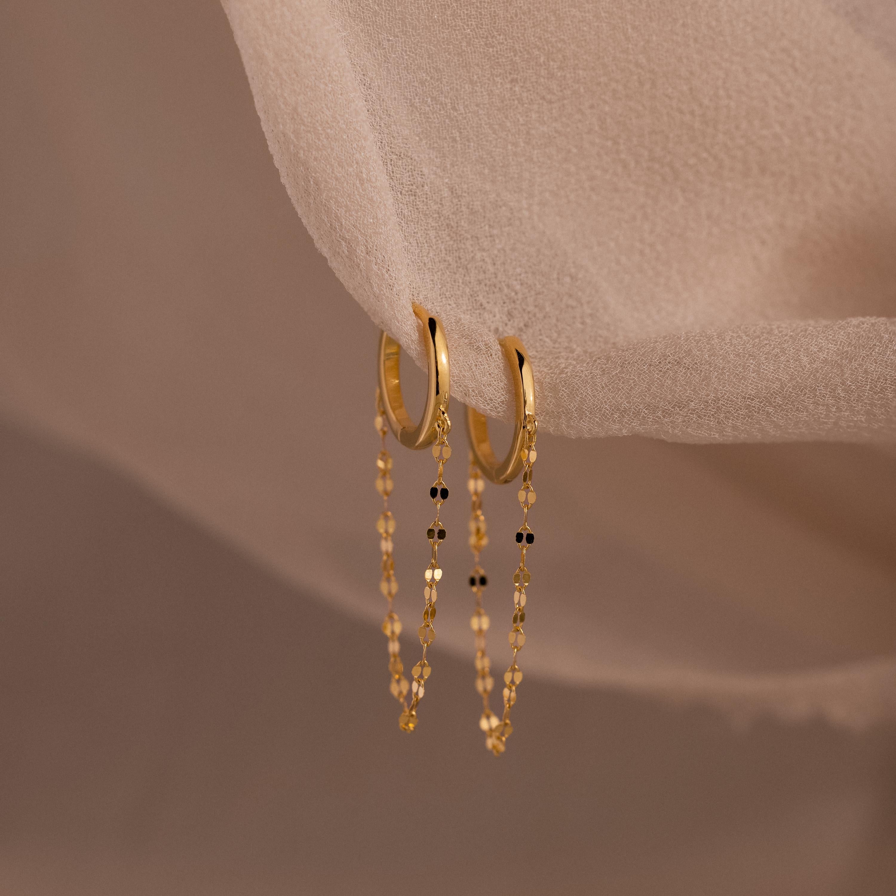 The Mirror Chain Huggies are gold hoop earrings featuring delicate chain details, perfect for adding minimalist elegance to any look.