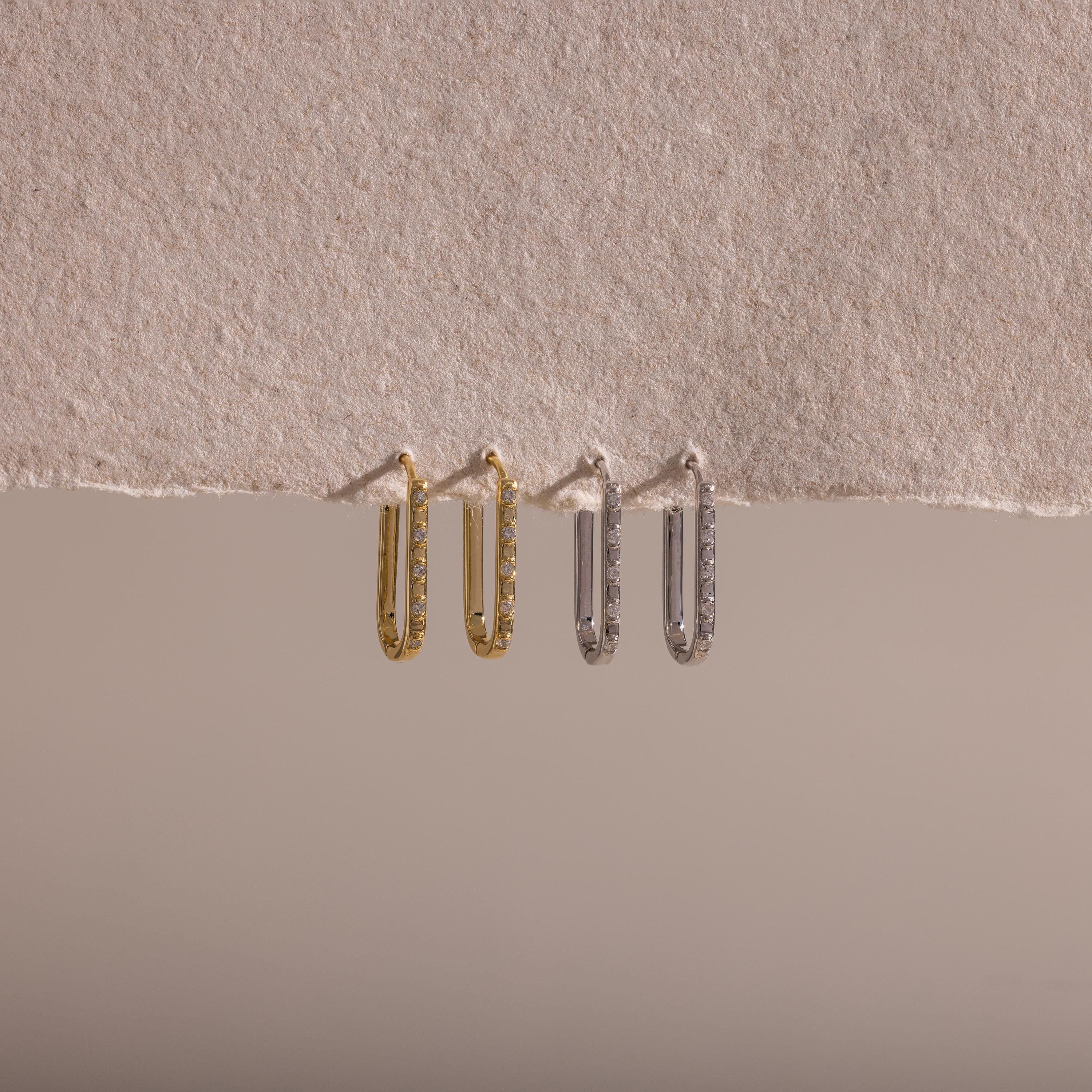 Two pairs of Dainty Pave Link Earrings—one gold, one silver—are displayed on textured beige paper, creating a minimalist look perfect for effortless everyday style.