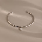 Pearl Cuff Choker Necklace in White Gold featuring a minimalist design with a single round white pearl pendant, displayed on a neutral background.