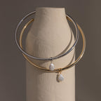 Two Pearl Cuff Choker Necklace in gold & white gold dangling on a vase