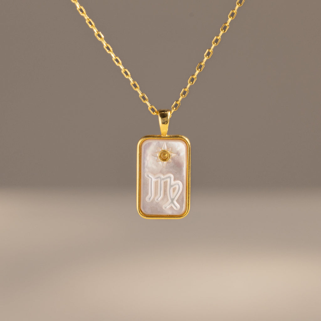 The Pearl Zodiac Birthstone Necklace features a gold rectangular pendant with the Virgo zodiac symbol on a pearly background—a stunning and unique piece of personalized jewelry.