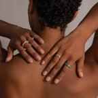 Model with short curly hair, hands on neck, shows her back while wearing the Jade Diamond Ring with a gold bezel and green jade accents.