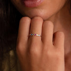 A hand near the lips showcases the Woven Multiple Birthstone Ring in Sterling Silver, a vintage-inspired jewelry piece adorned with colorful gemstones.