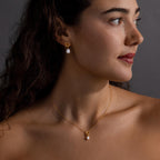 Woman with wavy hair wears the Pearl Knot Necklace & Earrings Set, looking to the right—a stunning gift for a wife who appreciates timeless elegance.