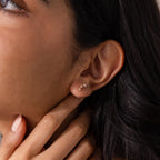 Close-up of a woman’s ear wearing Pink Tourmaline Cluster Flatback Studs, with her hand gently touching her neck.