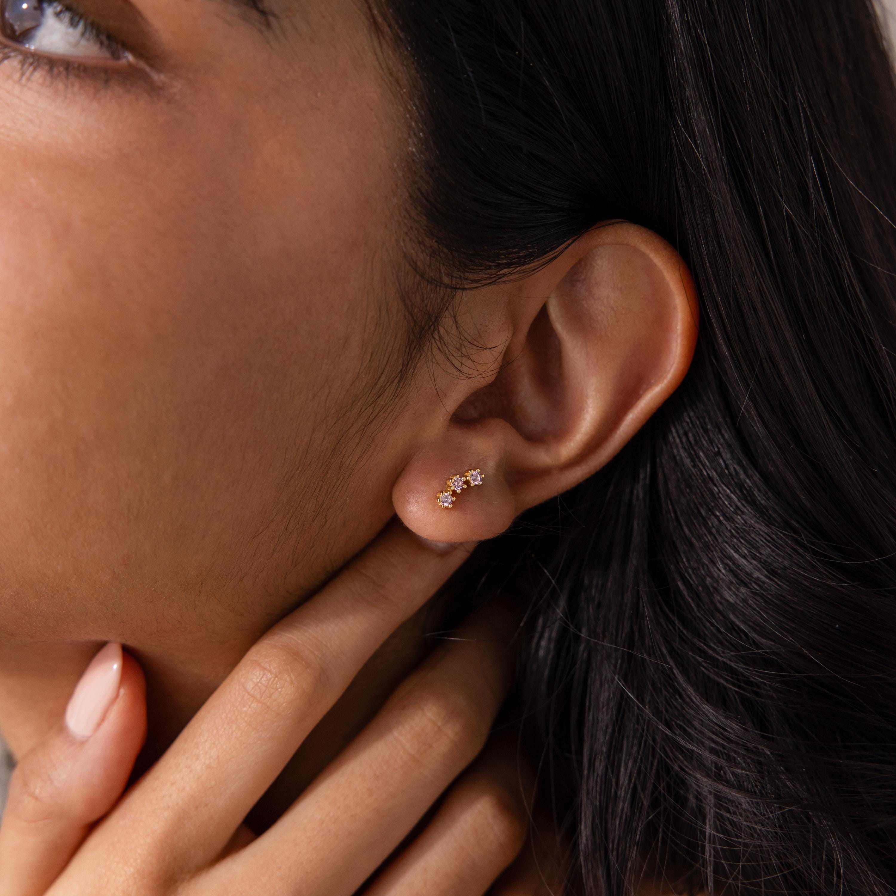 Close-up of a woman’s ear wearing Pink Tourmaline Cluster Flatback Studs, with her hand gently touching her neck.