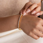A woman wearing a stunning 3-Prong Diamond Tennis Necklace & Bracelet Set in 18K Gold.