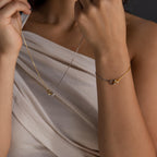 A woman in a cream top showcases the Interlocking Circles Necklace and Bracelet Set—a chic minimalist jewelry set with mixed metals and interlocking rings, perfect for any occasion.