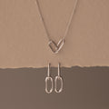 Linked Charm Necklace and Earrings Set in Sterling Silver, featuring interlocking hearts and oval links, shown on a beige background—an ideal anniversary gift.