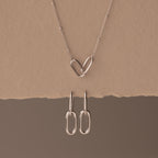 Linked Charm Necklace and Earrings Set in Sterling Silver, featuring interlocking hearts and oval links, shown on a beige background—an ideal anniversary gift.