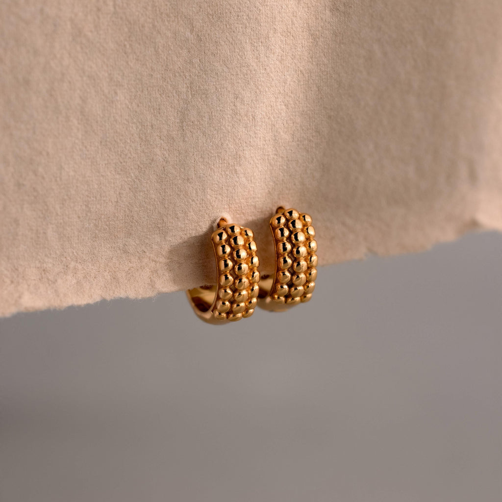Beaded Chunky Hoops showcased on beige paper with a neutral background, these earrings combine classic hoop style and modern flair.