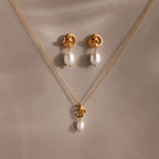 Pearl Knot Necklace & Earrings Set, featuring a gold knot design with single white pearls. Elegantly displayed on beige fabric. A thoughtful gift for your wife or someone special.