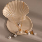 A shell-shaped dish holds the Pearl Knot Necklace & Earrings Set in gold and silver—an elegant gift for your wife.